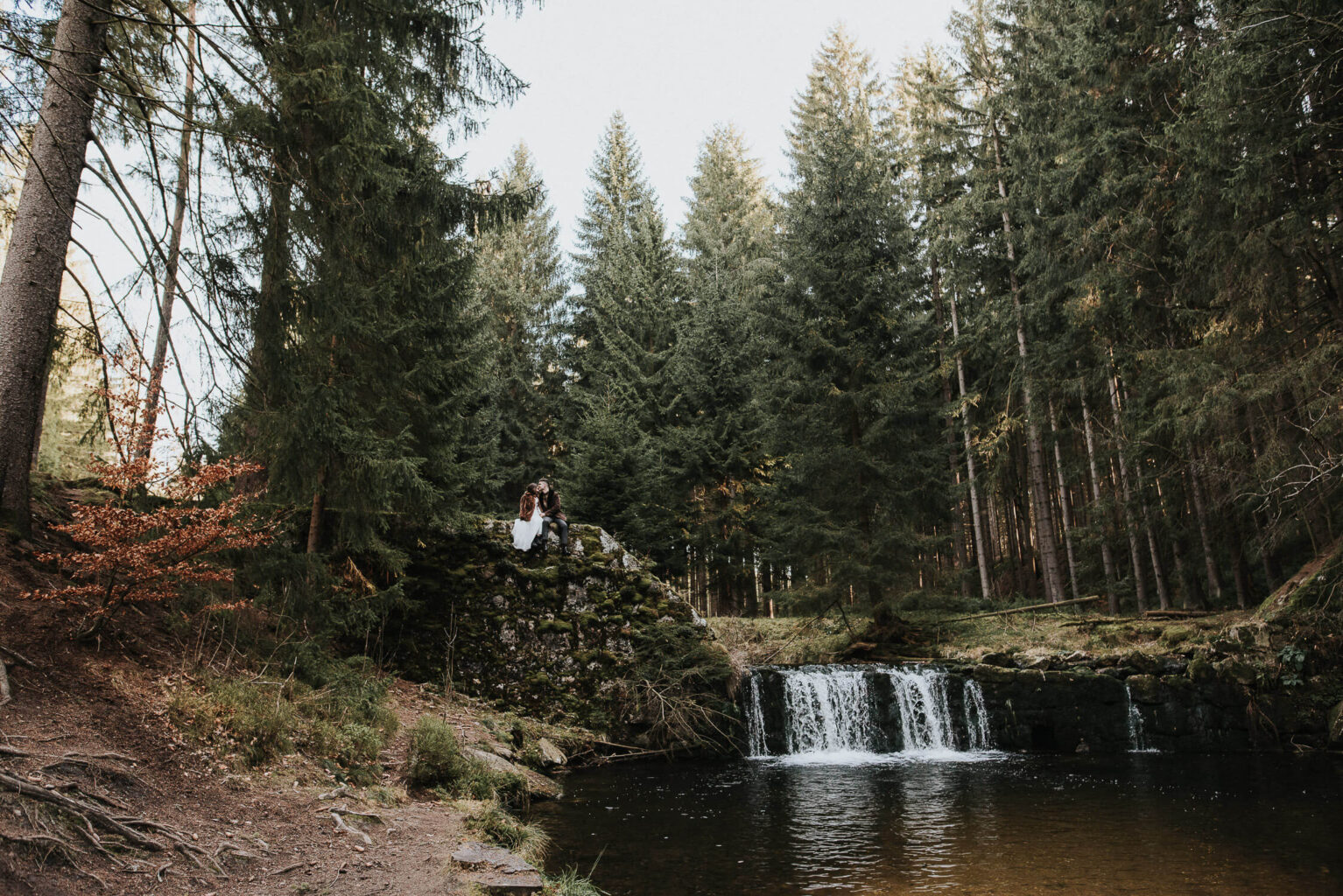 Kadr z naturalnej sesji ślubnej nad wodospadem w górach.